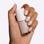 Hand holding a bottle of TT gel polish in almost pastel lavender with grey undertones for a delicate manicure
