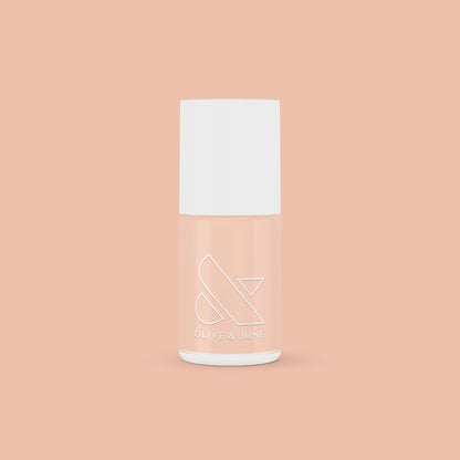 KAG nail polish bottle in neutral peachy pink shade on matching peach background for a fresh mani or pedi