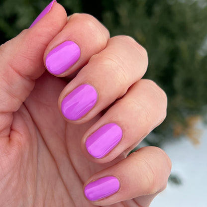 Hand with nails coated in glowing soft magenta Jam, Please polish for a smooth, long-lasting manicure by Olive and June
