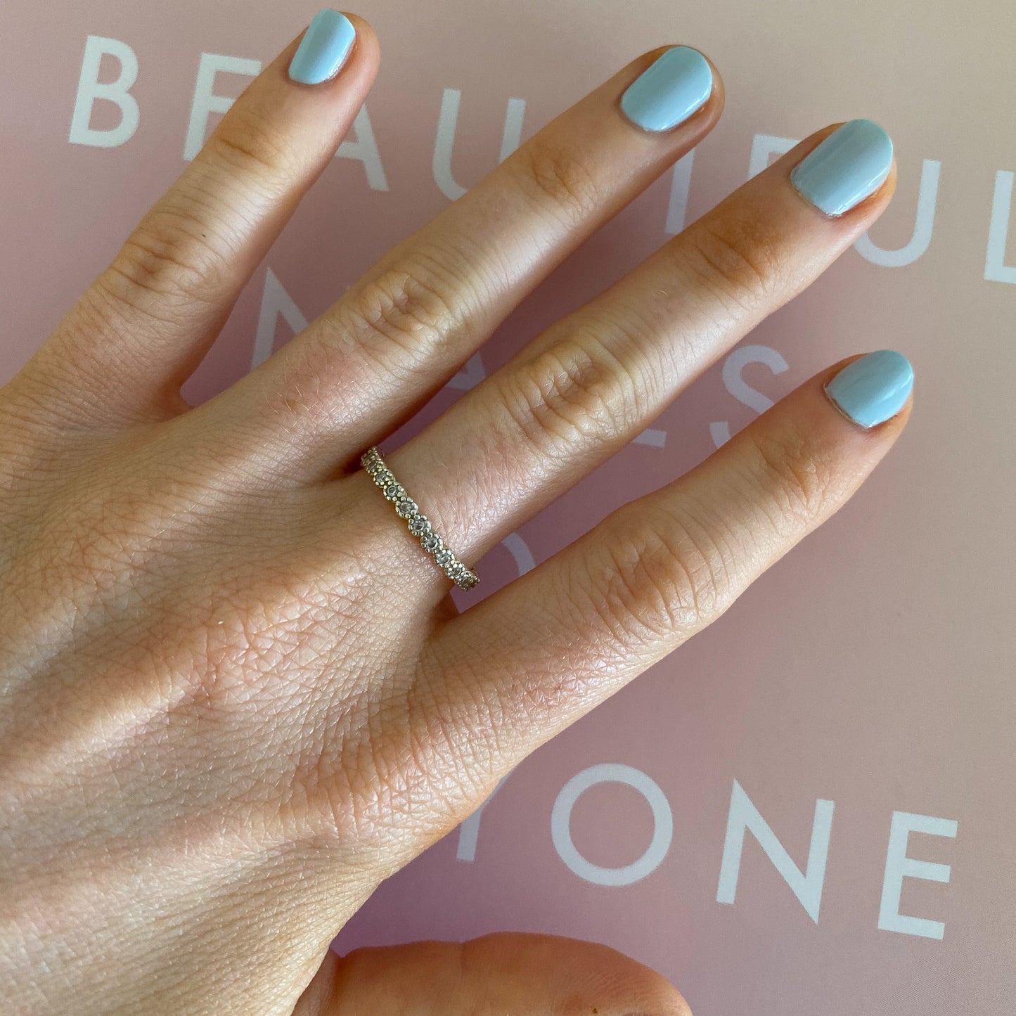 Hand with nails painted in Honest & True gel polish in a serene blue for a sleek, long-lasting at-home manicure look