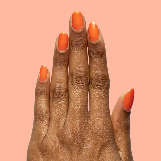Hand with matte nails painted in I’ll Take Another Spritz for a bright, long-lasting at home mani look