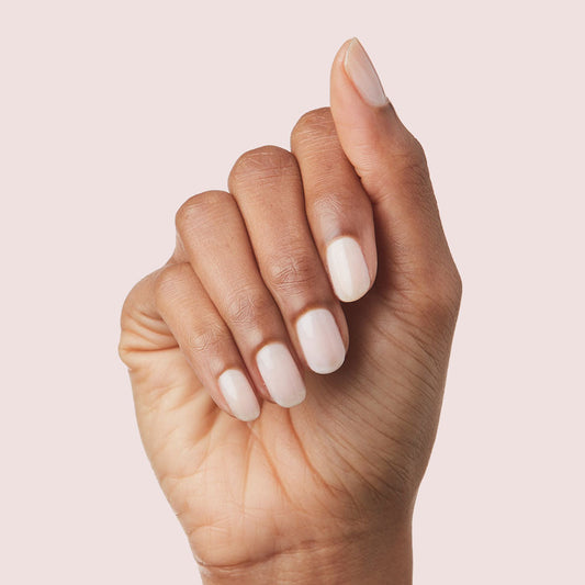 Hand with nails painted in sheer cool pink shade using Strawberry Scone polish for a natural manicure